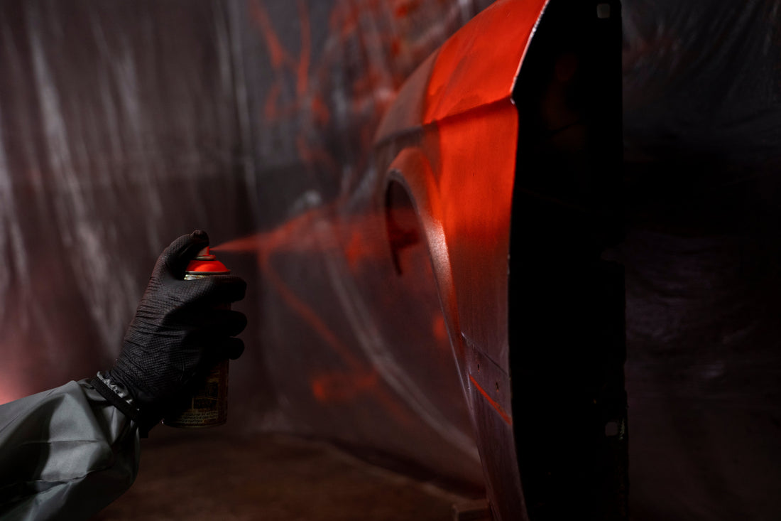 Spraylackering av bilpanel med billack i garage