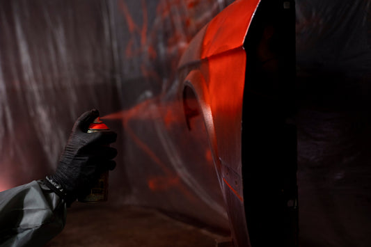 Spraylackering av bilpanel med billack i garage